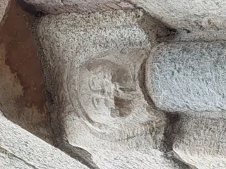 Portale dettaglio volto scolpito - Parrocchiale di San Massimo a Isasca